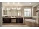 Spacious bathroom with double vanity, large mirrors, modern lighting, and soaking tub at 4084 E Rawhide St, Gilbert, AZ 85296