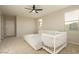 Spacious bedroom featuring a bed, crib, ceiling fan, large windows, and neutral walls at 4084 E Rawhide St, Gilbert, AZ 85296