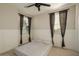 Bedroom featuring neutral walls, two windows with wooden blinds, and a modern ceiling fan at 4084 E Rawhide St, Gilbert, AZ 85296