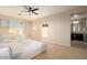 Large bedroom with a bed, crib, ceiling fan, a large window, and access to a full bathroom at 4084 E Rawhide St, Gilbert, AZ 85296