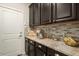Kitchen pantry features dark cabinets, granite counters, stainless steel appliances, and mosaic tile backsplash at 4084 E Rawhide St, Gilbert, AZ 85296
