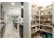 Walk-in pantry with multiple shelves, dark cabinets, granite countertops, and views of the open floor plan at 4084 E Rawhide St, Gilbert, AZ 85296