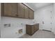 Well-equipped laundry room featuring upper cabinets, modern sink, and sleek washer/dryer hookups at 4211 E Desert Vista Trl, Cave Creek, AZ 85331