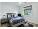 Comfortable bedroom with a wood-framed bed, blue bedding, and a window overlooking a green yard at 4507 E Weldon Ave, Phoenix, AZ 85018