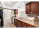 Modern kitchen featuring stainless steel appliances, granite countertops, and dark wood cabinets at 4533 S Terrace Rd, Tempe, AZ 85282