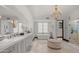 Bright bathroom featuring dual vanities, chandelier lighting, soaking tub, and glass-enclosed shower at 4743 N 54Th St, Phoenix, AZ 85018