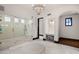 Bright bathroom showcasing walk-in glass shower, make up vanity, chandelier lighting, and ottoman at 4743 N 54Th St, Phoenix, AZ 85018