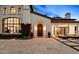 Elegant home featuring a beautiful arched doorway, manicured landscaping, and a paver driveway with lounging area at 4743 N 54Th St, Phoenix, AZ 85018