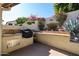 Outdoor kitchen area with a built-in grill, offering a perfect space for backyard barbecues at 5055 E Paseo Way, Phoenix, AZ 85044