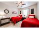 Cozy bedroom with twin beds, ceiling fan, and warm decor for a comfortable living space at 5055 E Paseo Way, Phoenix, AZ 85044