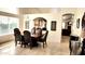 Elegant dining room with an archway view, dark wood dining table, and tile flooring at 5055 E Paseo Way, Phoenix, AZ 85044