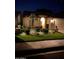 Attractive single-story home at night, showcasing professional landscape lighting and lush, manicured front lawn at 5055 E Paseo Way, Phoenix, AZ 85044