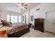 A bright main bedroom with a bay window, dark wood furnishings, and an ensuite bathroom at 5055 E Paseo Way, Phoenix, AZ 85044
