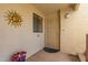Front entrance with decorative security door, potted flowers, and a sun-shaped wall decoration at 5518 E Lindstrom Ln # 2011, Mesa, AZ 85215