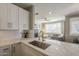 Open kitchen with white cabinetry, stainless steel sink, and view into living room, perfect for entertaining at 7009 E Acoma Dr # 1044, Scottsdale, AZ 85254