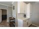 A charming kitchenette featuring white cabinets, a coffee maker, and a stylish bar cart for storing glassware at 7009 E Acoma Dr # 1044, Scottsdale, AZ 85254