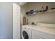 Functional laundry area with a washer, dryer, and shelving for storage at 7009 E Acoma Dr # 1044, Scottsdale, AZ 85254