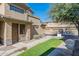 Side angle of the tan home featuring a walkway, grass, and desert landscaping at 705 W Queen Creek Rd # 2158, Chandler, AZ 85248