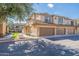 A tan two-story townhome with a two-car garage and low-maintenance landscaping at 705 W Queen Creek Rd # 2158, Chandler, AZ 85248