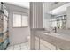 Bright bathroom with white tile flooring, updated vanity, and a shower with patterned curtain at 7607 N 22Nd Pl, Phoenix, AZ 85020