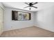 Bedroom featuring a ceiling fan, neutral carpet, and window with dark wood trim at 7607 N 22Nd Pl, Phoenix, AZ 85020