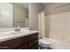 Bathroom featuring a white vanity sink, dark wood cabinets, mirror, and a shower and bathtub combo at 8430 W Atlantis Way, Tolleson, AZ 85353
