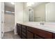 Bathroom featuring wood cabinets, double sinks, large mirror, and access to shower/tub combo at 8430 W Atlantis Way, Tolleson, AZ 85353