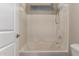 Bathroom featuring a white shower and tub combo, white tiling, and a small window at 8430 W Atlantis Way, Tolleson, AZ 85353