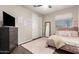 Bedroom featuring a full bed, TV, dresser, soft pink rug, and sliding door closet at 8430 W Atlantis Way, Tolleson, AZ 85353