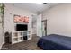 Bedroom featuring a full bed, TV, shelving unit, and a door with a mirror at 8430 W Atlantis Way, Tolleson, AZ 85353