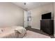 Bedroom features a full bed, TV, dresser, soft pink rug, and view to the hallway at 8430 W Atlantis Way, Tolleson, AZ 85353