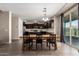 Dining area with wooden table and chairs, next to sliding glass doors, and open to the kitchen at 8430 W Atlantis Way, Tolleson, AZ 85353
