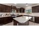 Well-equipped kitchen with stainless steel appliances, central island, and tile backsplash at 8430 W Atlantis Way, Tolleson, AZ 85353