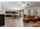 Inviting living room featuring a cozy brown couch, open to the kitchen and dining area at 8430 W Atlantis Way, Tolleson, AZ 85353
