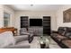 Inviting living room featuring two chairs, dark wood bookcases, and a glass coffee table at 8430 W Atlantis Way, Tolleson, AZ 85353