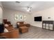 Spacious living room with tile floors, a brown couch, a ceiling fan, and neutral-colored walls at 8430 W Atlantis Way, Tolleson, AZ 85353