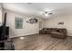 Spacious living room with a sectional couch, ceiling fan, and multiple windows at 8430 W Atlantis Way, Tolleson, AZ 85353