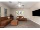 Bright living room featuring a comfortable couch, ottoman, and modern artwork at 8430 W Atlantis Way, Tolleson, AZ 85353