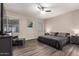 This spacious main bedroom features wood-look flooring, fan, and large windows for a naturally well-lit space at 8430 W Atlantis Way, Tolleson, AZ 85353