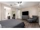 This main bedroom features wood-look flooring, a fan, ensuite bath and large windows for a naturally well-lit space at 8430 W Atlantis Way, Tolleson, AZ 85353