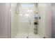This bright shower features a glass door, shower caddy, and a handheld shower head at 8430 W Atlantis Way, Tolleson, AZ 85353