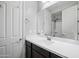 Bright bathroom featuring a white sink, dark cabinets, and a large mirror reflecting the shower at 10024 E Tamery Ave, Mesa, AZ 85212