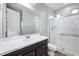 Modern bathroom features a white sink vanity with shower and glass door at 10024 E Tamery Ave, Mesa, AZ 85212