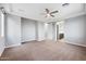 Large bedroom with neutral carpet, ceiling fan, and an ensuite bathroom at 10024 E Tamery Ave, Mesa, AZ 85212