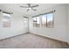 Bright bedroom featuring neutral carpet, a ceiling fan, and three large windows at 10024 E Tamery Ave, Mesa, AZ 85212