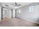 Spacious bedroom with neutral carpet, closet, and natural light from multiple windows at 10024 E Tamery Ave, Mesa, AZ 85212