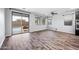 Bright living room boasts wood-look tile floors, a ceiling fan, and a large glass sliding door to the backyard at 10024 E Tamery Ave, Mesa, AZ 85212