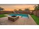 Backyard with a sparkling pool, fire pit, and lush green grass at 10024 E Tamery Ave, Mesa, AZ 85212