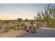 Balcony view overlooking desert landscape and nearby homes with distant mountain views at sunset at 110 W Yellow Bee Dr, San Tan Valley, AZ 85143