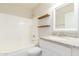 Clean bathroom with a shower-tub combo, wood shelves, and granite countertop vanity at 110 W Yellow Bee Dr, San Tan Valley, AZ 85143